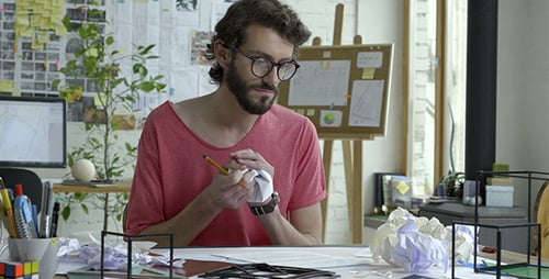 Man Drawing Geometric Shapes and Crumpling Paper