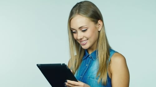 Smiling Woman Using Tablet Device in Studio