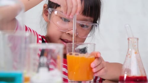 Enthusiastic Child Mixing Liquid in Science Experiment