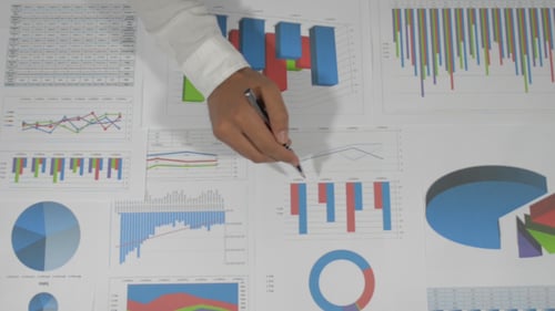 Hand Analyzing Business Charts and Graphs with Pen