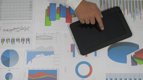 Hand Draws on Tablet Overlying Data Charts