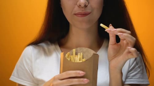 Woman Eating French Fries From Container