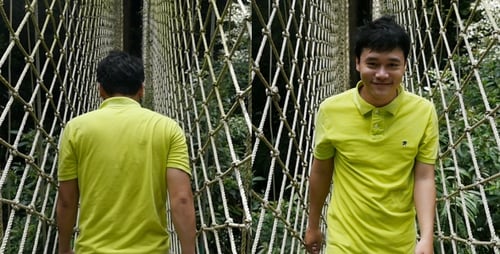 Homme asiatique marchant sur le pont suspendu