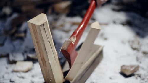 Axe Splits Wood in Snowy Winter