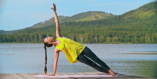 Woman Doing Yoga on Dock by a Lake