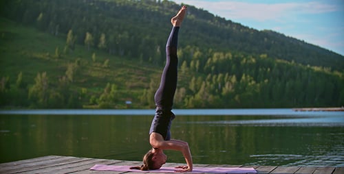 Woman Doing Yoga on Dock at Lake
