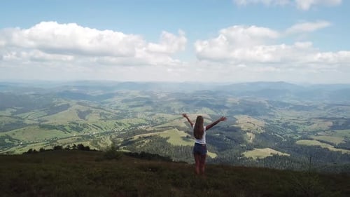 Woman Enjoying Mountain View with Arms Outstretched