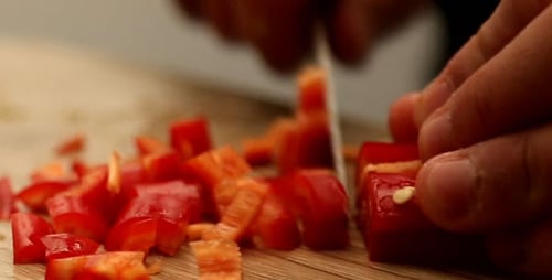Chopping Red Bell Pepper with Knife on Cutting Board