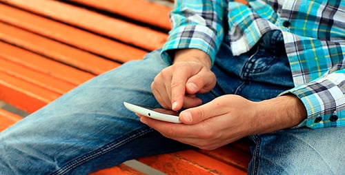 Junger Mann benutzt Touchscreen-Telefon