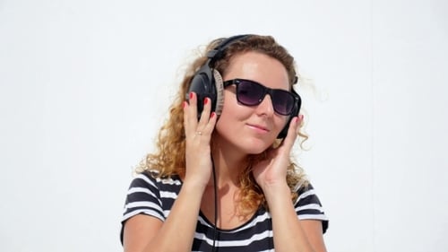 Woman with Headphones Listening to Music and Dancing