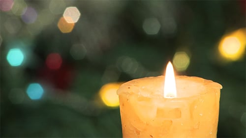 Christmas Candle Burning with Blurred Background Lights