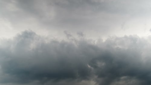 Wolken bewegen sich im blauen Himmel.