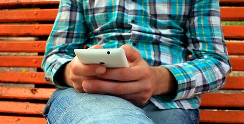 Man Using Tablet on Orange Bench
