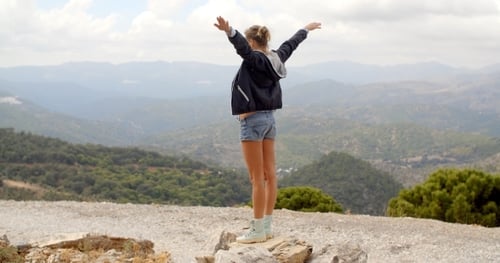 Sporty Woman Standing On Top Of Rock
