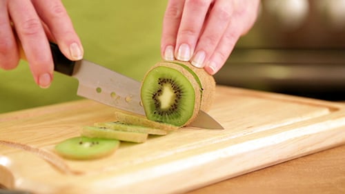 Slicing Fresh Kiwi on Cutting Board
