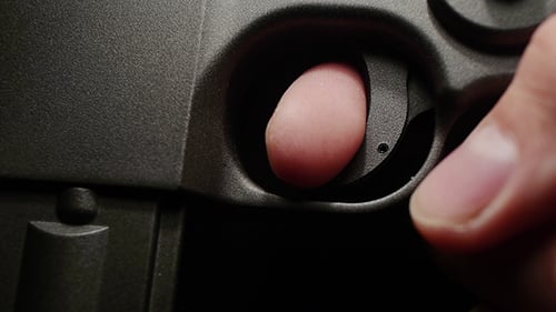Finger Pulling Trigger of Black Pistol Close Up