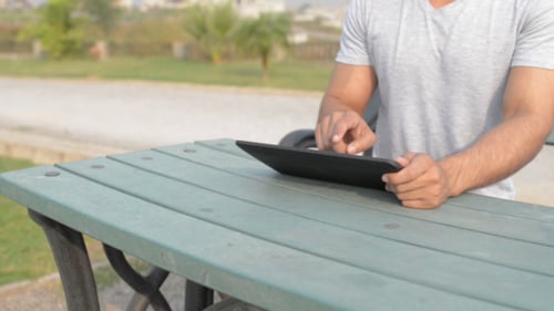 Entspannen Sie den jungen Mann mit dem Tablet