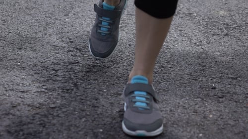 Legs Walking on Paved Road