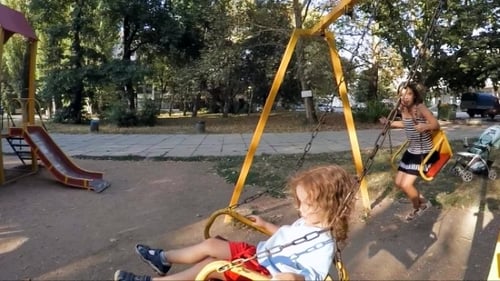 Girls Playing on Swings in Summer Park