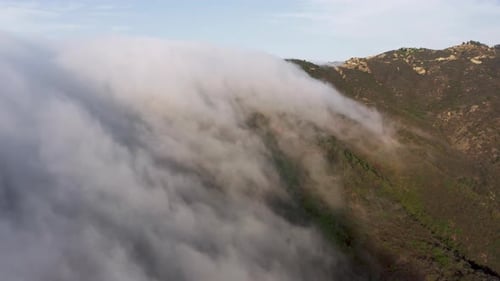 Aerial Mountains Landscape with Scenic White Clouds Soaring on Top of Green Peak