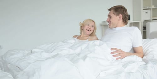 Paar liegt im Bett und plaudert