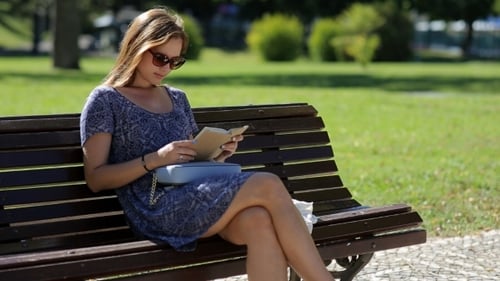Young Woman Reading on Park Bench