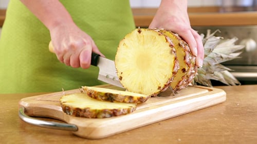 Slicing a Fresh Pineapple on a Cutting Board
