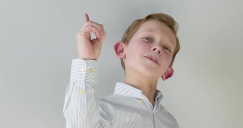 Close-up Portrait. The Boy Is Raising a Finger Up.