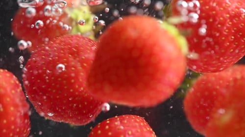 Strawberry Spinning and Splashing Into Water on Black Background