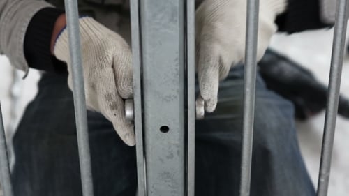 Worker Assembling Metal Frame With Nuts and Bolts