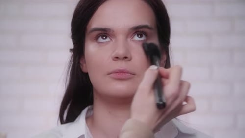Makeup Artist Applying Face Powder to a Woman