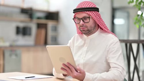 Professional Young Arab Businessman Using Tablet in Office
