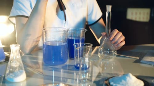 Lab Technician Works with Beakers and Flasks
