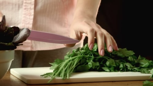 Woman Chopping Fresh Herbs in Kitchen