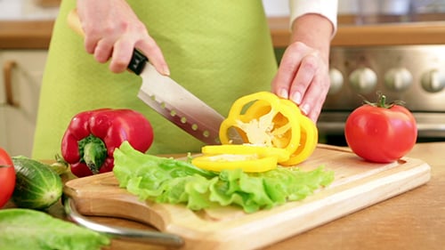 Slicing Yellow Bell Pepper with Fresh Vegetables