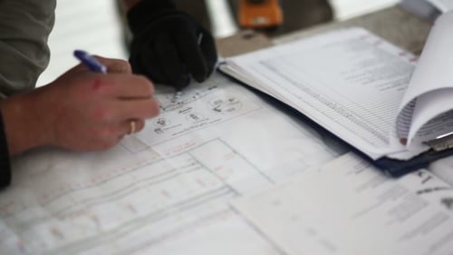Ingenieur und Arbeiter überprüfen Blueprint-Arbeit