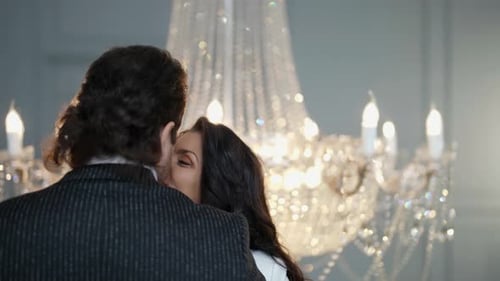Romantic Couple Embracing Under Chandelier Indoors