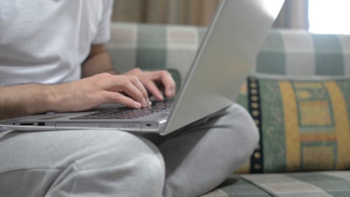Young Adult Typing on Laptop at Home