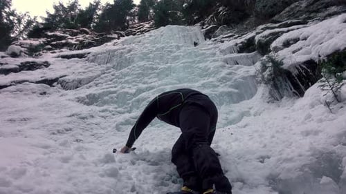 Climbing Frozen Ice. Hammer In Hand Crampons On Boots