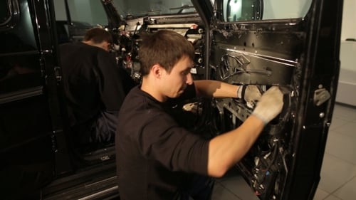 Mechanics Repairing Interior of Black SUV