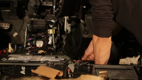 Man Repairing Car Dashboard Interior
