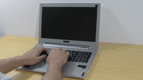 Hands Typing on Laptop Computer Keyboard Indoors