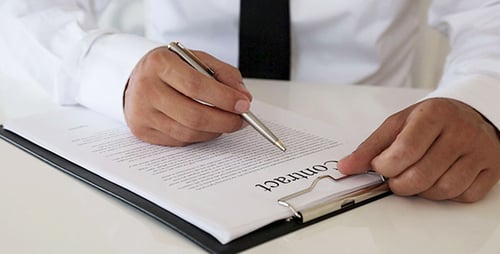 Signing Business Contract at Desk with Pen