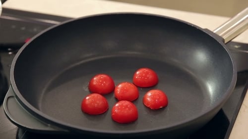 Chef Is Putting Half Cut Cherry Tomatoes On a Hot