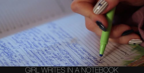 Woman's Hands Writing Notes in Notebook