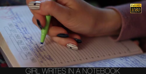 Hand writing in notebook with green pen