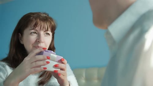 Woman Receives Gift from Man, Hugs Him