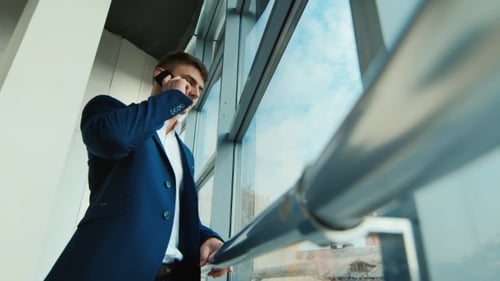 Young Adult Man Talking on Phone in Modern Office