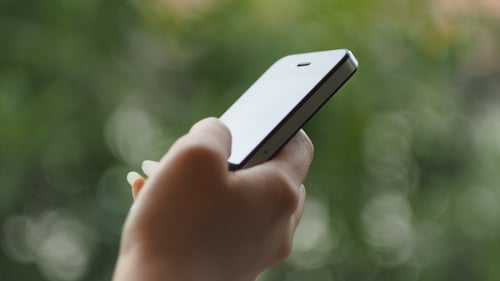 Hand Taps Screen of Cell Phone