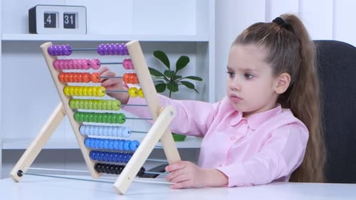 Niña con camisa sentada a la mesa y le dijo al multicolor Aba